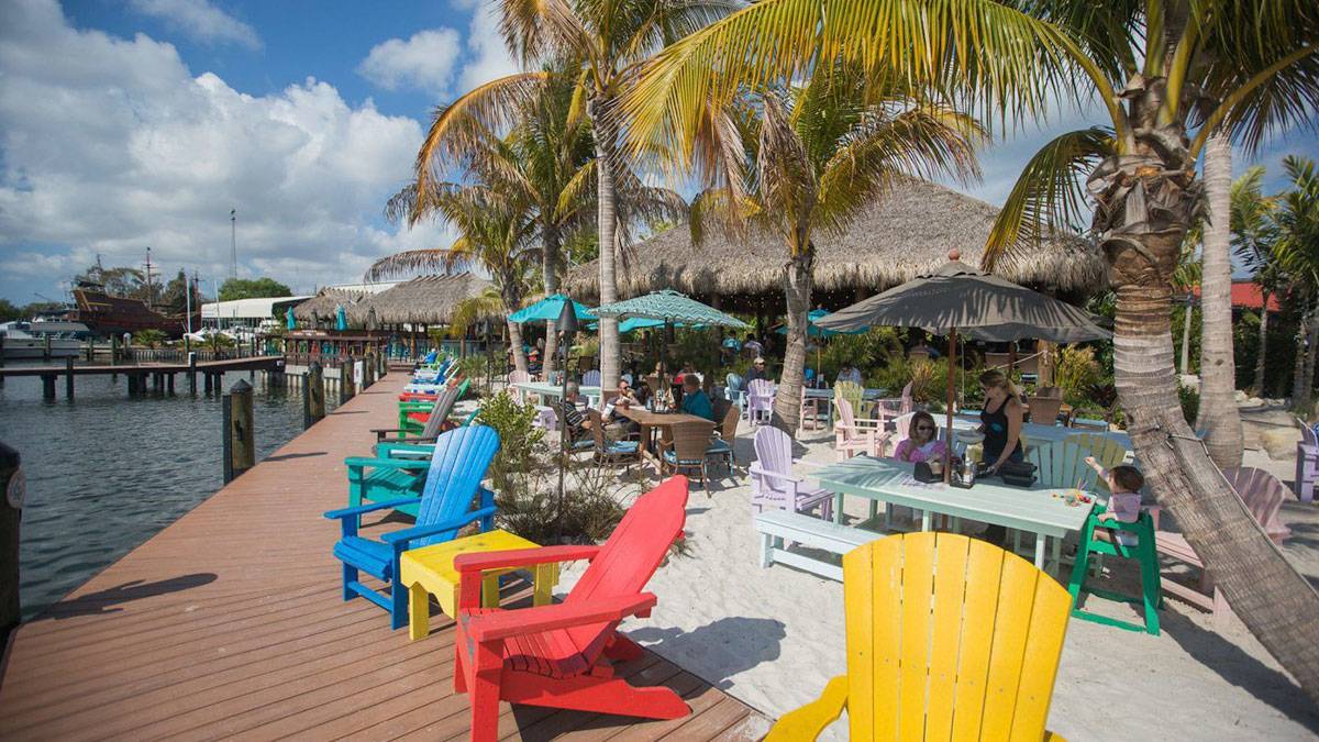 colorful deck chairs along bay water with palm trees outside the getaway restaurant in st petersburg near tampa florida